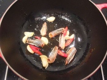 step3: 熱鍋後加入一匙油爆香蒜頭辣椒及蝦頭。(喜歡口味重一些,這時可先加入一匙XO干貝醬一起拌炒)