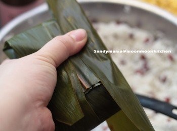 step3: 14.將兩邊糉葉向內摺起。
15.每邊再包上一塊糉葉，如圖中摺起，再用水草紮起。
16.用大煲注入清水，用中大火煲3小時。