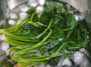 step4: 菠菜洗淨，切去根部，放滾水中川燙1分鐘，撈起，放入一盤冰水中至完全冷卻後，放入筲箕瀝乾水分；然後用手揸乾菜的水分，把菜切成小段，加入少許麻油和醬油拌勻備用。