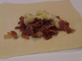 step3: 取出派皮一張，將培根餡料鋪在中間，再擺一點點乳酪絲