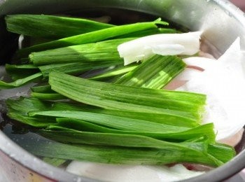 step1: 先將豬腳洗淨後，放入冷水鍋中，加入青蔥段與蒜段及少許的洋蔥和米酒一起滾煮川燙撈起沖洗，豬大腸也是重覆上述的步驟滾煮川燙起鍋沖洗