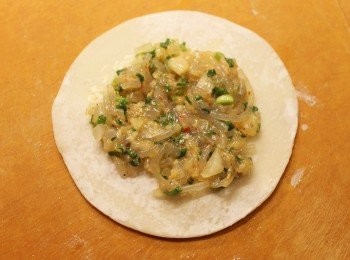 step5: 以小碗盛載少許清水, 取一餃子皮, 把適量餡料放到餃子皮正中央。