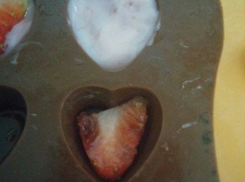 step3: 將一至兩片士多啤梨放入模內，注入乳酪至八成滿，再鋪上一片士多啤梨。