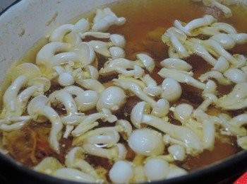 step4: 煮20分鐘後，湯汁呈現金黃色，再加入米酒與雪白菇下去燉煮