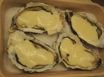 step2: 在生蠔上撒上少許鹽和黑胡椒粒調味，再在上面淋上芝士醬汁。