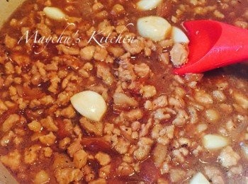 step5: 加入葱酥、瘦肉和蒜頭，攪勻煮滾後轉細火加蓋燜1小時。不要開蓋熄火焗1小時。再煮滾後轉細火加蓋再燜1小時，然後再焗1小時。吃前翻熱即可享用。