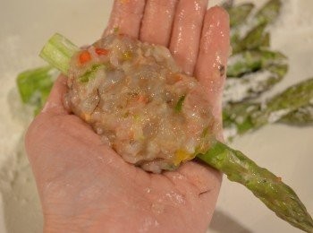 step5: 然後均勻地沾上一層薄薄的生粉，這樣可讓饀料黏附著蘆筍，炸時才不會鬆出。取適量已冷凍好的餡料包裹在蘆筍中段，露出頭、尾綠色部份。