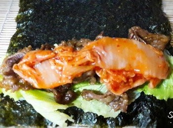 step4: 把蘿蔓生菜洗淨瀝乾水氣放到海苔上 , 舖上炒好的牛肉 , 再加上泡菜 , 然後連同保鮮膜壓緊卷起
