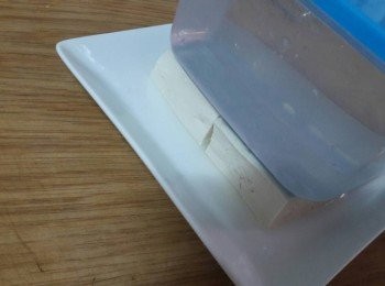 step2: 首先把豆腐從中間剖開 , 再用重物壓上 , 十五分鐘後把水倒掉即可