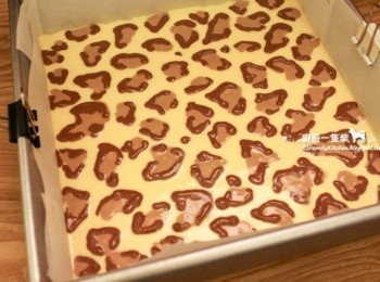 step8: 再剪開「深咖啡色」起司糊的塑膠袋一角，勾勒出深色的豹紋邊，送入預熱好的烤箱中層，烘烤35~40分鐘。(乾烤即可，不需隔水烘烤。但因每台烤箱溫度多少有些差異，如果蛋糕表面膨脹得太高或裂得太快，可以降溫或是把烤箱門打開散熱一下)