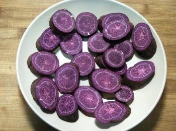 step2: 取出一個盤子，步驟1的帶皮切片地瓜放入後，置入電鍋，外鍋放1杯水，蒸煮。