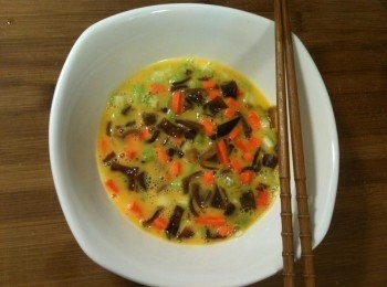 step2: 【調製蛋液】：將切丁黑木耳、切丁紅蘿蔔和切丁西洋芹放入蛋液中，灑上黑胡椒、白胡椒、義大利香料和鹽，攪拌均勻。