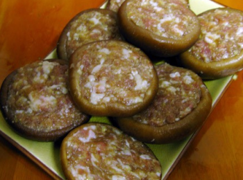 step3: 冬菇洗淨，釀入豬肉，燒好鍋把釀好的香菇放入煎香，再將調好的碗汁倒入到鍋中，同時加入大蒜1瓣、1片薑片，1根香蔥，蓋好鍋蓋，中小火燉煮片刻