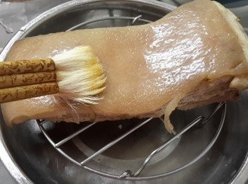 step5: 拿出豬腩肉，再用豬針或刀在豬皮上插孔，再用布吸乾豬皮上的水份及油份。在豬皮上塗一層油
