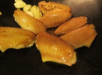 step2: 下油锅煎香两面鸡翅至金黄，弄去一旁，再爆香姜片，蒜头和豆瓣酱，然后将鸡翅和醬料炒勺，加入其它调味料和八角，少许水焖约十分钟，开盖略炒至汁收浓既可。