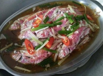 step2: 用大鍋把水燒滾，將清蒸紅魚【澎湖野生水產】放入鐵盤上，鐵盤上外鍋也要放少許的水，再開大火清蒸15分鐘。 並在清蒸紅魚【澎湖野生水產】身上鋪好薑絲，淋上少許的醬油和水， 【金蘭醬油對甘醇始終如一的堅持，採透明瓶裝醬油，讓品質清楚看得見。】