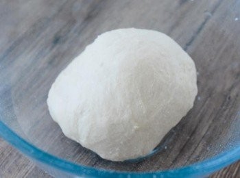 step4: 在工作枱灑上麵粉。大力搓麵糰約十分鐘，麵糰太乾可加點水，太濕可加點麵粉。搓至麵糰表面平滑及有韌性。在大碗內塗一層植物油，放入麵糰，用保鮮紙包好，靜置一小時或至麵糰脹大一倍