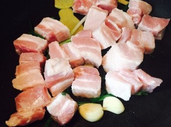 step1: 燒熱砂鍋或鑄鐵鍋，熱油先爆香薑、蒜頭及葱段。放入切件腩肉，爆香至表面呈金黃色。