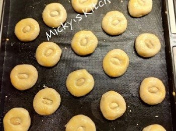 step4: 將麵團平均分割每粒15g，然後搓圓，放上已鋪牛油紙焗盤（每粒距離一粒位置）。在麵團面放上一粒花生粒，然後向下按入。蛋黃用叉打散，在麵團表面掃上蛋液（包括花生面）。