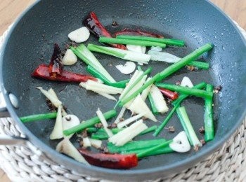 step3: 然後下乾辣椒，辣椒粉及花椒粒，炒一分鐘，令辣味散發。再下蔥段，薑絲及蒜片，再炒一分鐘，下所有<span class="group_2">調味料</span>拌勻