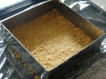 step1: 先將消化餅乾擀碎，與溶化牛油拌勻，倒入模具底內均勻壓實，放入雪櫃冷卻30分鐘