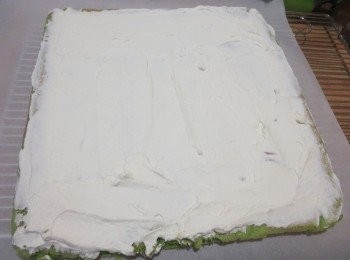 step7: 正卷的话要把蛋糕重新盖一张新的油纸，将蛋糕翻转过来，铺上打发好的淡奶油（ 淡奶油 100g +糖12g）