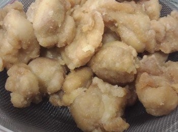 step2: 把步驟(1)逐一蘸滿生粉用中火炸至金黄浮起用篩瀝乾多餘的油，再放回油煱內轉大火炸四十秒，這樣可以迫出炸物的油份使口感更香脆。撈起瀝乾油份備用。