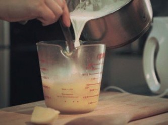 step4: 慢慢將熱奶倒入蛋汁中攪勻,然後再倒回煲內加入拔蘭地酒拌勻關火