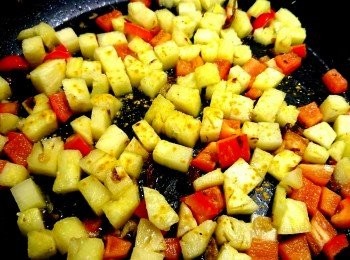 step5: 取出平底鍋，放入步驟3的鳳梨丁、紅甜椒丁、洋葱丁，開中火乾煸（不用放油）。鳳梨焦糖化後，灑上薑黃粉，拌炒一下。