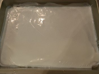 step4: 取一個不黏平底盤，然後將適量煮好的椰汁倒進，用手輕輕地搖動平盤使椰汁均勻形成一層薄薄的膜，放置一旁待凝固。（約1分鐘就可凝固）