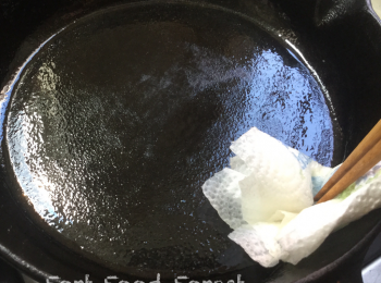 step6: 用中火燒熱平底鍋, 落油. 將一張㕑房紙重複對摺成一小塊, 然後用筷子或夾子夾着, 給平底鍋塗一層薄油.