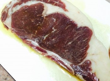 step1: 肉眼扒用廚房紙抹乾。先用橄欖油塗匀牛扒兩邊，方便之後將調味黏隱。