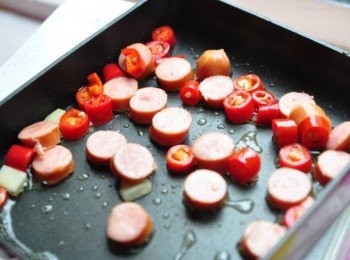 step2: 以2大匙油熱鍋，先放入辣椒與德國香腸爆香略炒