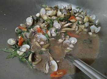 step2: 倒入黑麻油熱鍋，先把蒜頭、薑片放入鍋中爆香，待香氣出來時，放入一斤半的黃金蜆、倒入少許醬油、米酒、塩巴、放入辣椒，開大火並悶鍋3-5分鐘 ;