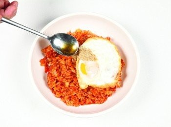 step10: 將炒好的泡菜炒飯盛盤，放上荷包蛋，再撒上芝麻鹽與香油¼ 大匙即可。