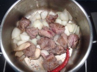 step1: 將切塊的牛小排放入鍋裡煸至表面焦香狀,再放入洋蔥及薑片,辣椒及蒜頭拌炒至洋蔥變透明狀。
