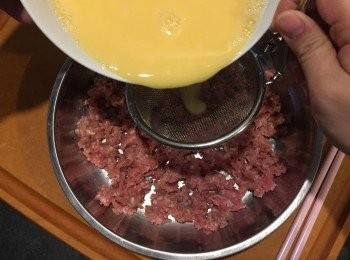 step4: 將蛋液過濾倒入不鏽鋼碟，用筷子輕輕攤平豬肉碎。