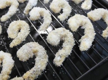 step4: 將蝦仁沾上蛋液然後裹上椰子絲~並且壓一壓蝦仁幫助椰子絲固定!! 把蝦仁放在烤盤上~在每顆蝦仁表面淋上一點點油!! 放入預熱200度的烤箱烤約12-15分鐘~烤至表面成金黃色^^