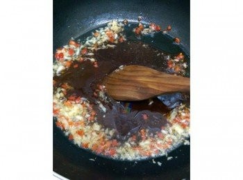 step3: 雞肉炸熟之後撈起來瀝乾油，在乾淨的平底鍋裡放一小匙的油，爆香蒜蓉和紅辣椒丁之後把<span class="group_3">醬汁</span>倒進去煮開