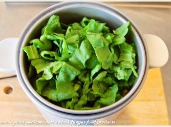 step5: 待電鍋跳起後，放入已洗淨並分切成段的茼蒿葉，蓋上鍋蓋悶3分鐘。