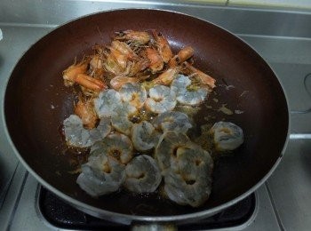 step2: 起油鍋將蒜片炸香後備用，同鍋下蝦頭煎至蝦油出來後再下蝦仁，