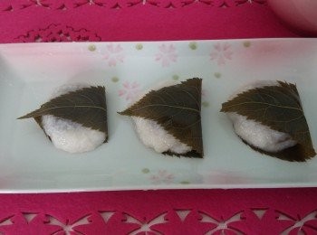 step6: 將面團分成10等份，弄濕手心，將面團搓成圓餅形，把紅豆蓉放於中心用面團包好，包上櫻花葉即成。