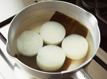 step5: 將昆布鋪入鍋內，再放入洗好的白蘿蔔。接著加入淹過白蘿蔔的水量，以中火加熱至蘿蔔芯也熱透為止。
