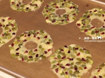 step8: 取出醒好的南瓜籽麵糊，以湯匙舀起，間隔式地排在鋪有不沾烤布或矽膠烤墊的烤盤上，以手指沾少許清水均勻將麵糊推薄推平，避免南瓜籽或杏仁片重疊。