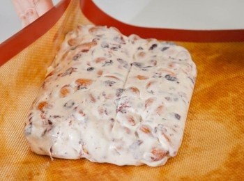 step7: 糖果粉團温度經不斷搓拌會逐慚泠却開始變硬, 所以要在還熱時用矽膠刮取出放入不黏布內，戴手套返覆搓後放入不銹網盤，用麵棍轆平成形