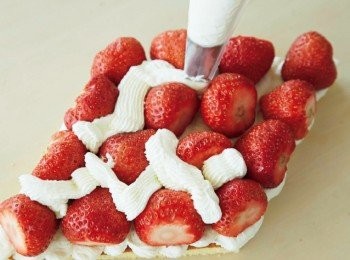 step14: 草莓去蒂，將切口朝向外側擺放在蛋糕表層。在縫隙中擠入發泡鮮奶油。