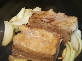 step3: 熱鑊下油加入洋葱和蒜頭爆香，再加入牛肋骨煎至兩面金黃