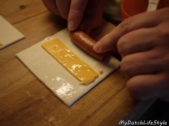 step3: 起司至中，派皮邊緣塗上蛋液，最後小熱狗一併捲入。
