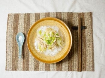 step5: 在麵碗依次放進河粉、大蔥炒雞絲和蔥花，倒入高湯，灑一把芝麻，澆一小匙芝麻油。