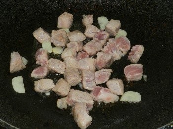 step4: 起一油鍋，爆香蒜片後，下豬五花丁快炒